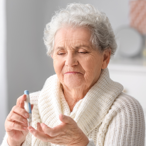 Elderly woman measuring blood sugar